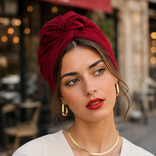 Mujer con turbante burdeos de algodón en un estilo urbano y elegante.