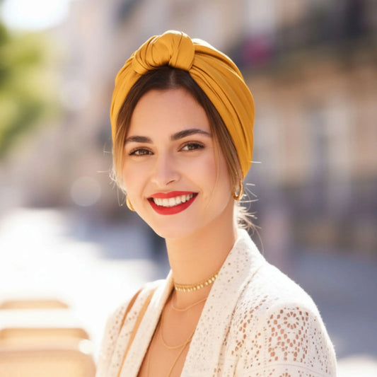 Mujer con turbante parisino miel dorado visto de frente, con un estilo cálido, elegante y effortless chic.