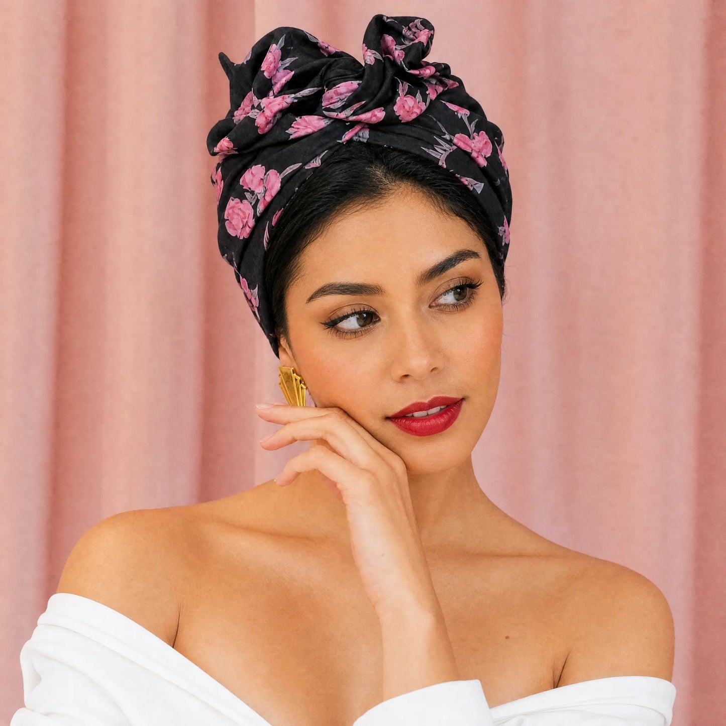Mujer inclinando ligeramente la cabeza con turbante Cubano Rosa Negra y estilo elegante