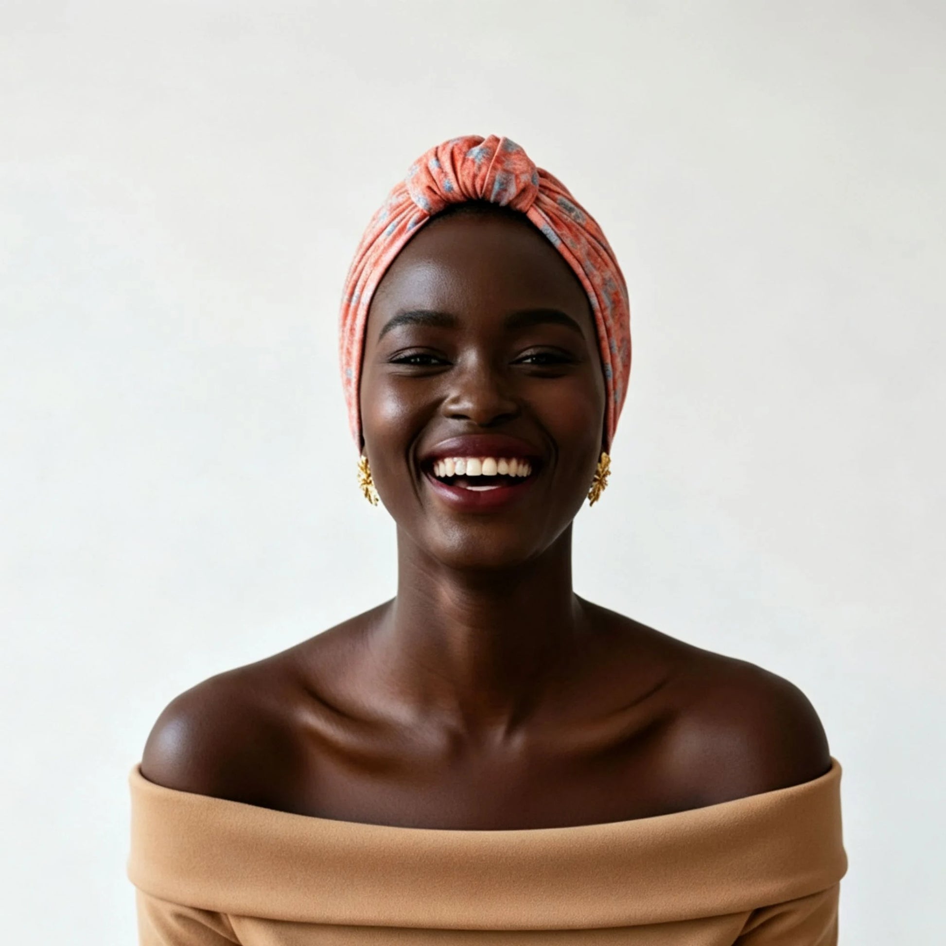 Mujer sonriente con turbante Parisino Coral de algodón 100% sobre fondo blanco