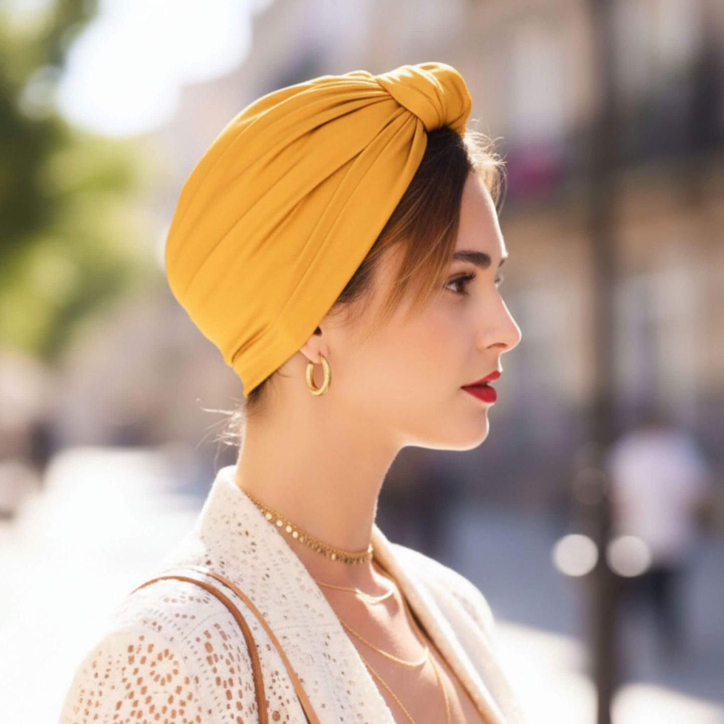 Mujer con turbante parisino miel dorado visto de perfil, estilo suave, natural y sofisticado inspirado en el look parisino.
