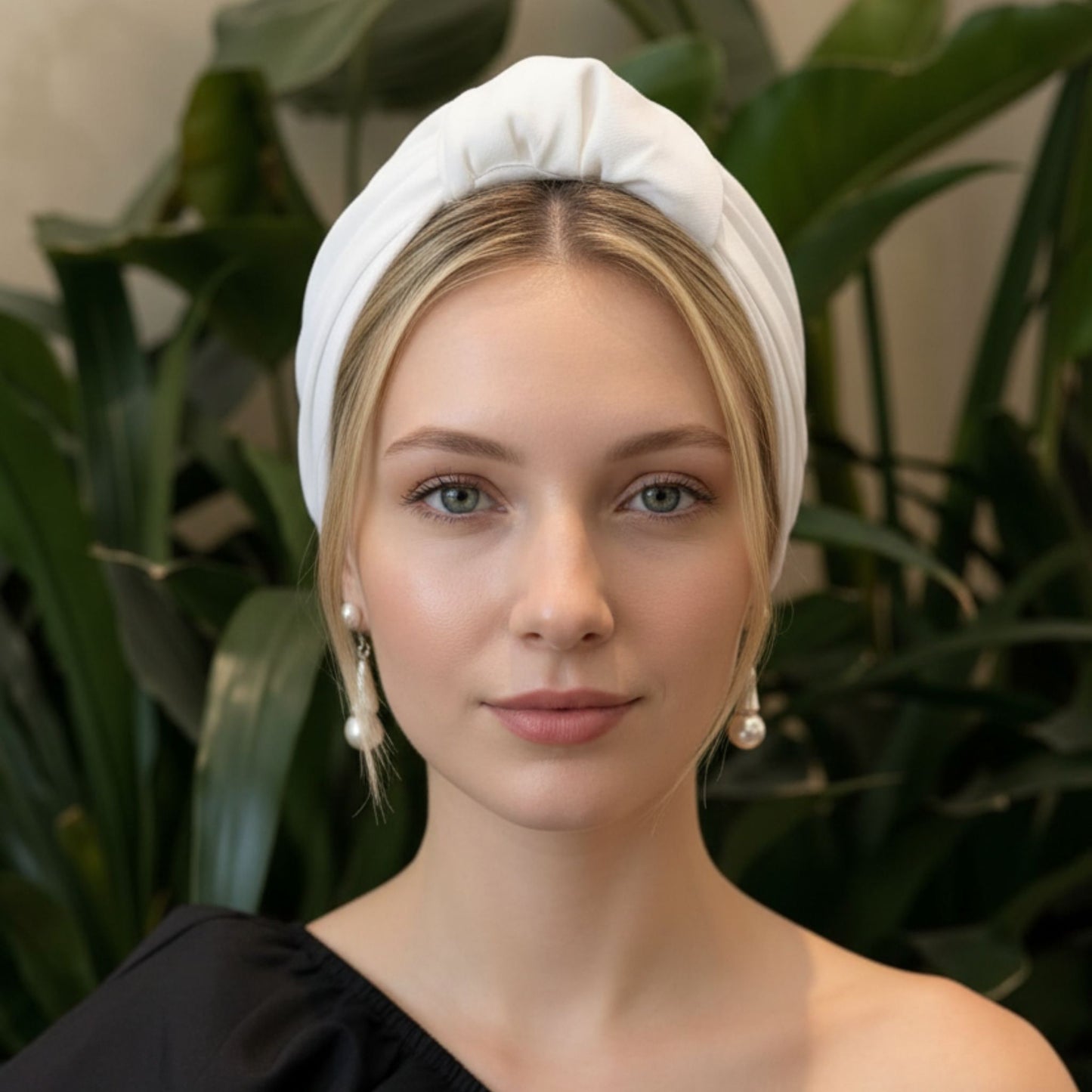 Mujer con turbante parisino de color perla blanca visto de frente, estilo elegante, limpio y minimalista.