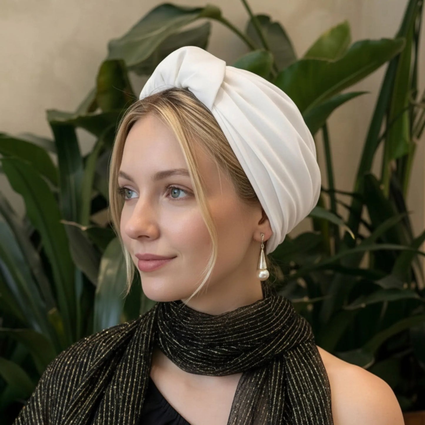 Mujer con turbante parisino perla blanca visto de perfil, con un estilo suave, elegante y natural.
