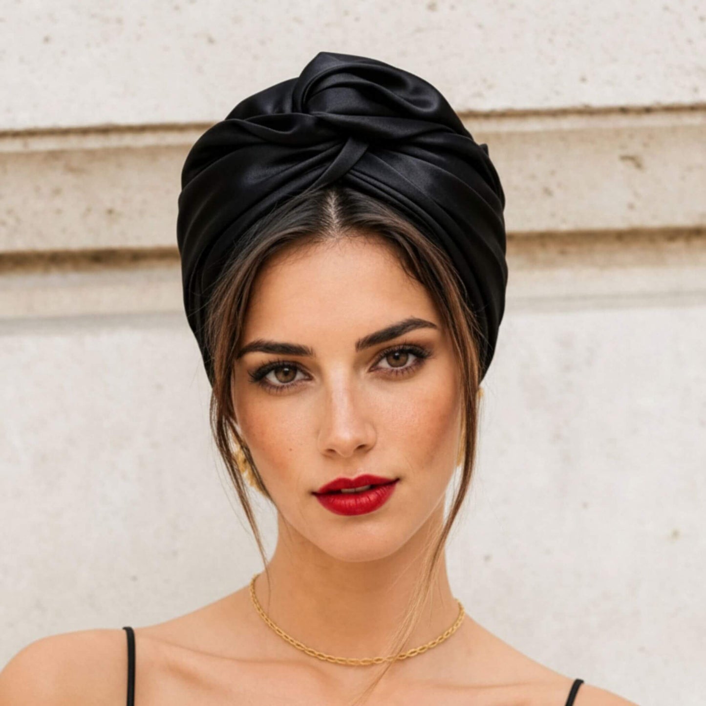 Mujer con turbante de satén negro visto de frente, estilo cubano elegante y minimalista para un look sofisticado en segundos.