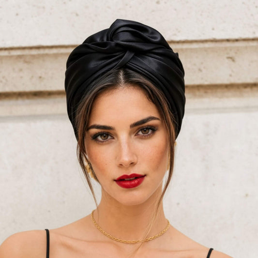 Mujer con turbante de satén negro visto de frente, estilo cubano elegante y minimalista para un look sofisticado en segundos.
